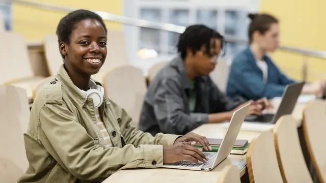 Smiling participant with a laptop in a training session